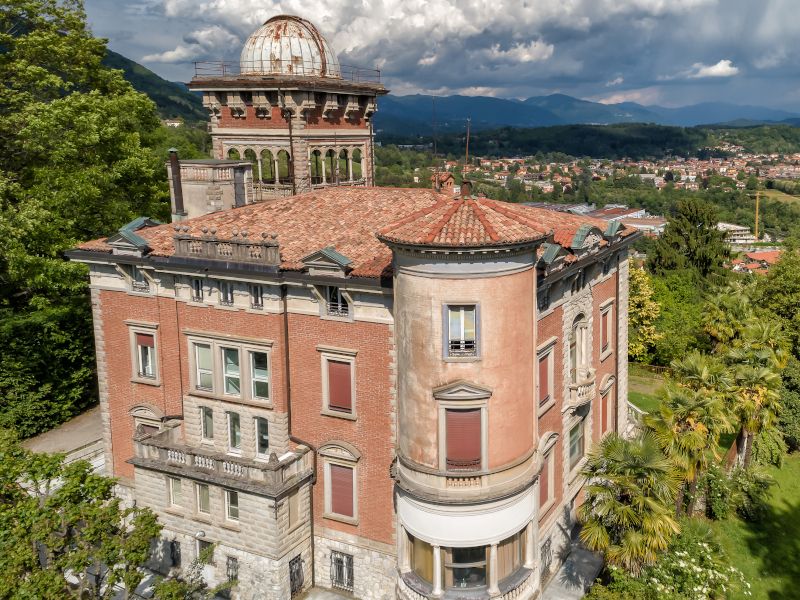 Villa, alberi, case in distanza, colline, nuvole