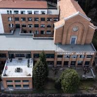 Edificio in mattoni rossi della sede di Via Ravasi a Varese, balcone del Rettorato e alberi