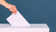 mano che infila scheda elettorale nell'urna