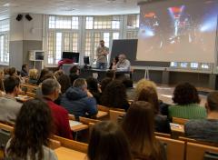 Studenti a lezione in aula, con docente e lavagna luminosa