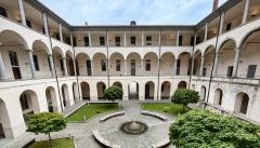 Vista sul chiostro di Sant'Abbondio con archi e prato