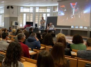 Studenti a lezione in aula, con docente e lavagna luminosa